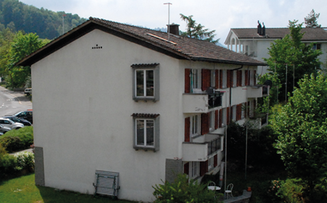 Bestehendes Gebäude mit Bauprofilen und sichtbaren Putzschäden an den Balkonbrüstungen.